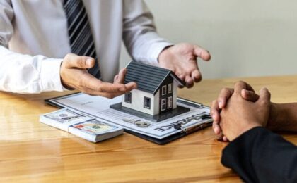 A two person talking at table and home toy, papers, money on table