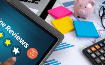 laptop and sticky notes, calculator, piggybank, glass on a table